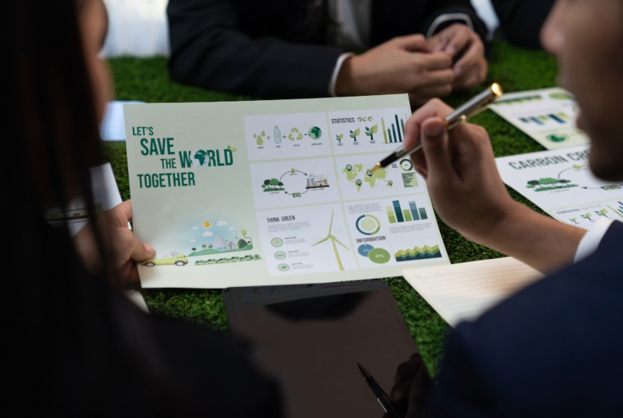 Business team reviewing an eco-friendly sustainability report with environmental graphics, renewable energy data, and green business initiatives.